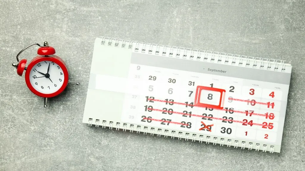 Kalender mit markiertem Datum und Wecker symbolisiert Frist für Kündigungsschutzklage